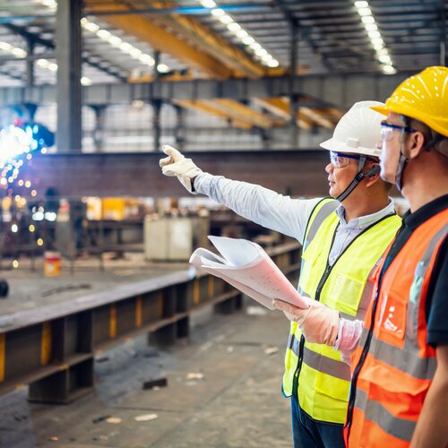 Two construction workers in steel factory